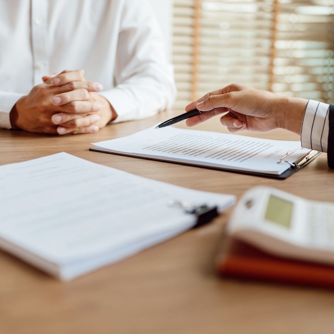 discussing paperwork with agent, calculator on table