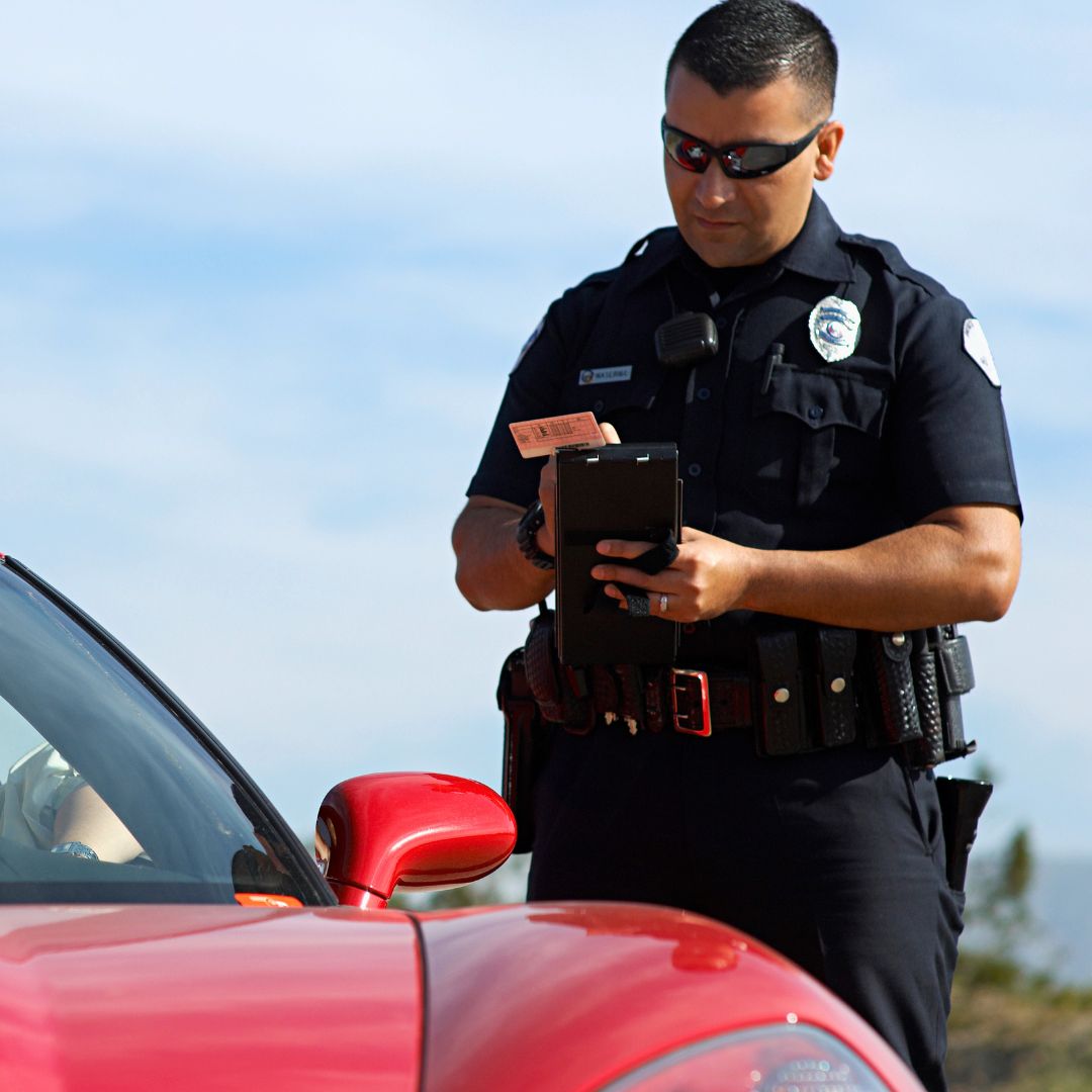 A cop pulling over a woman in a red car